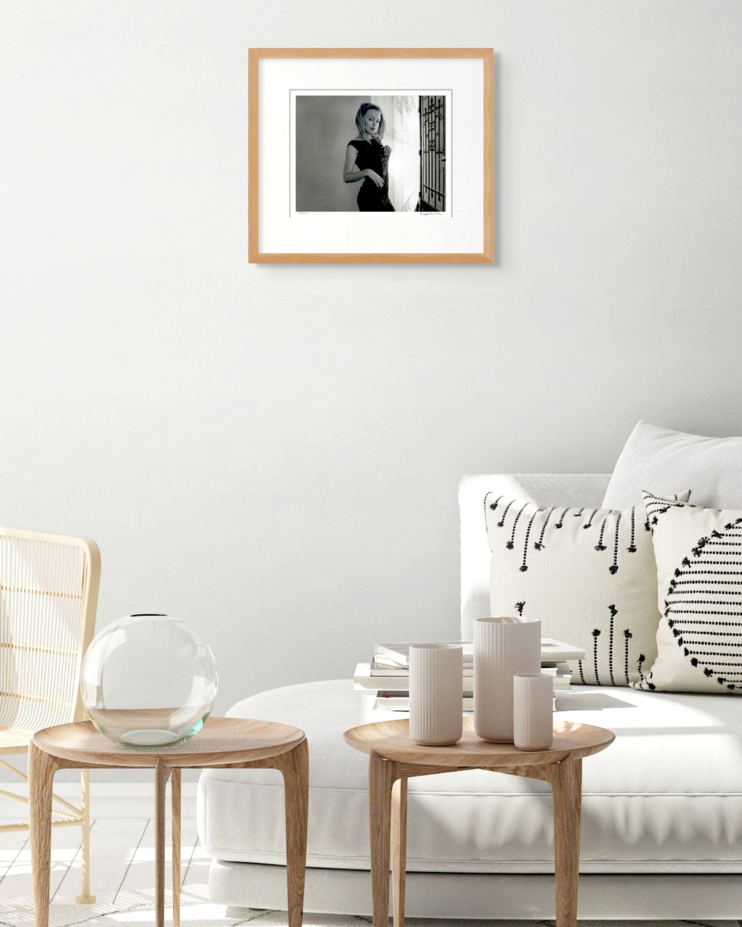 Framed Kylie Minogue portrait by Robin Sellick displayed above a white couch with soft neutral styling – contemporary Australian interior.