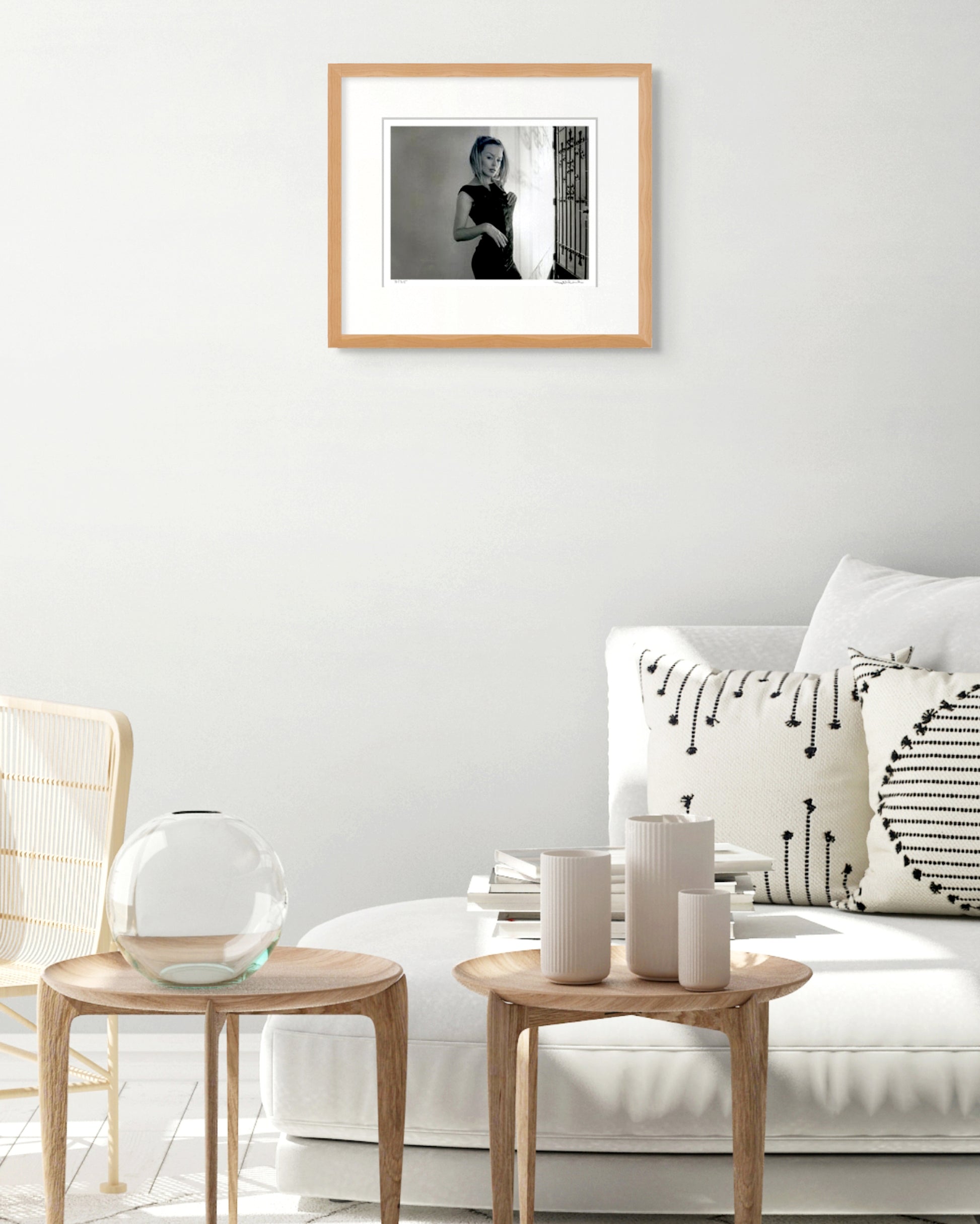Framed Kylie Minogue portrait by Robin Sellick displayed above a white couch with soft neutral styling – contemporary Australian interior.