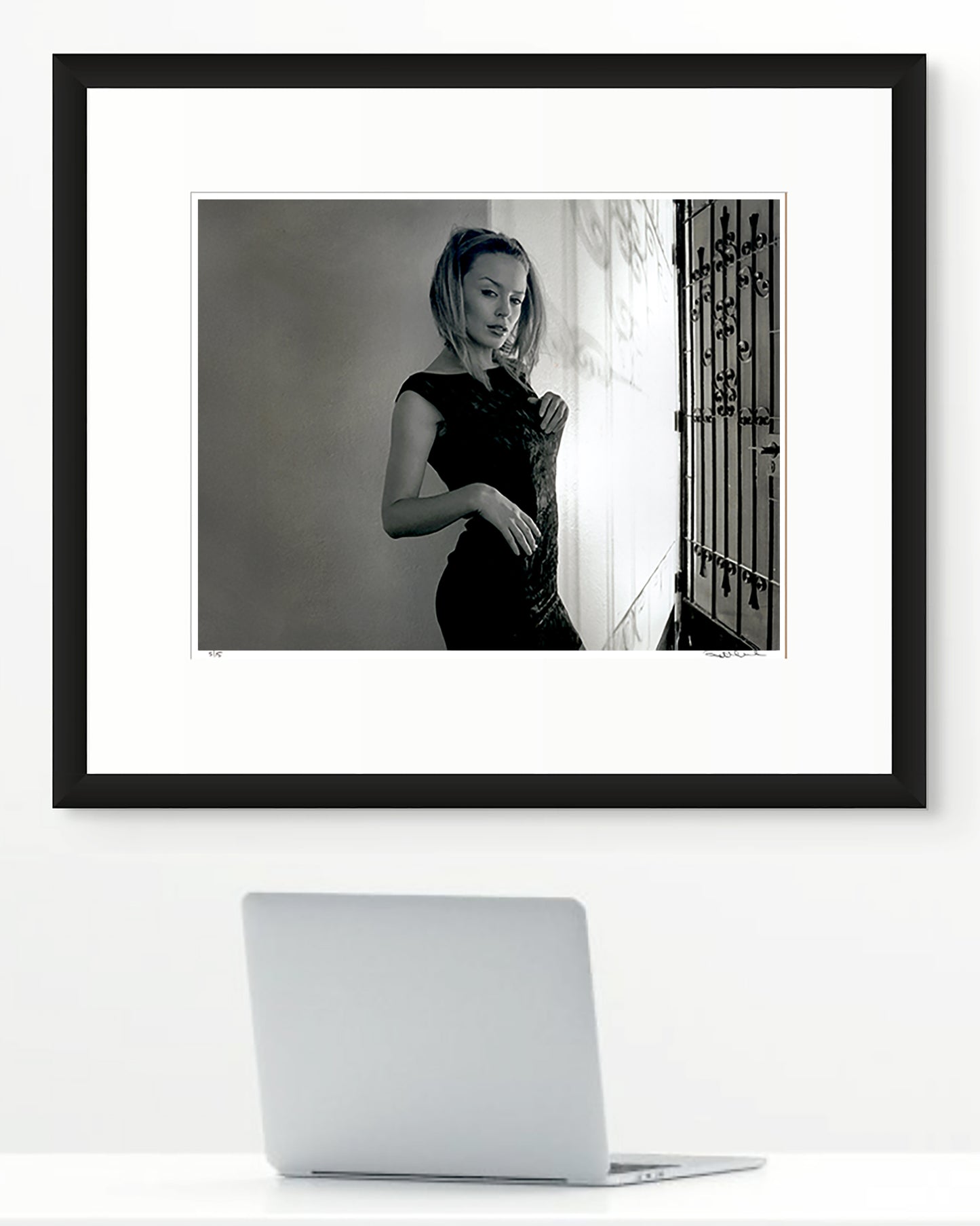 Framed black and white photographic portrait of Kylie Minogue by Robin Sellick, part of the Collector Edition series – displayed in a modern interior with laptop on a desk