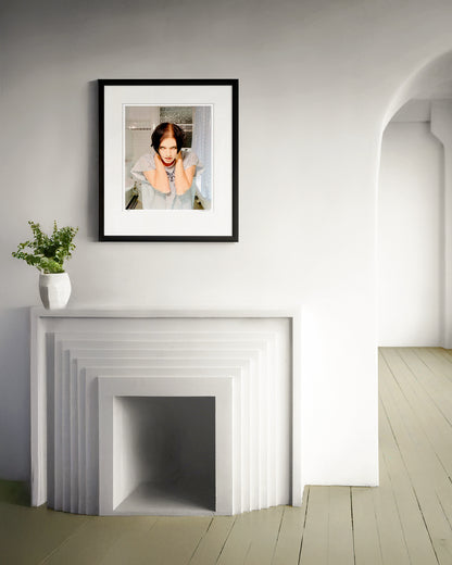 Collector Edition framed photographic portrait of Brian Molko by Robin Sellick, displayed in a minimalist white interior above a sculptural fireplace.
