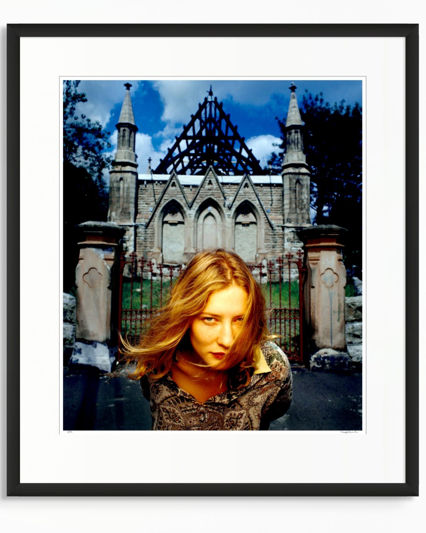 Framed colour photographic portrait of Cate Blanchett photographed in Woollahra, Sydney in 1994, standing before a Gothic stone structure, by Robin Sellick.