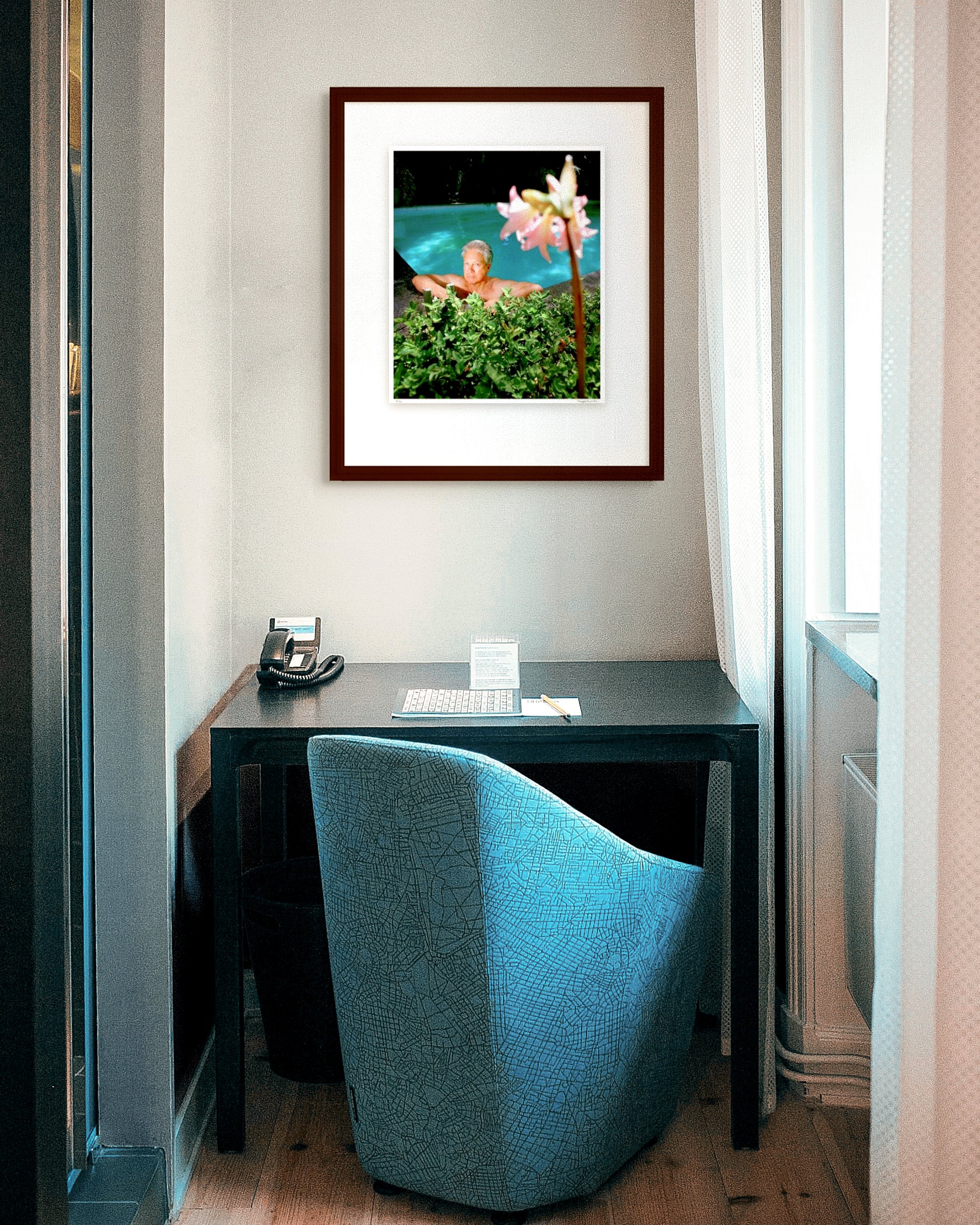 Framed photographic portrait of Don Dunstan by Robin Sellick, part of the Medium Edition series – Dunstan reclining by a pool surrounded by greenery, captured in vivid colour and natural light.