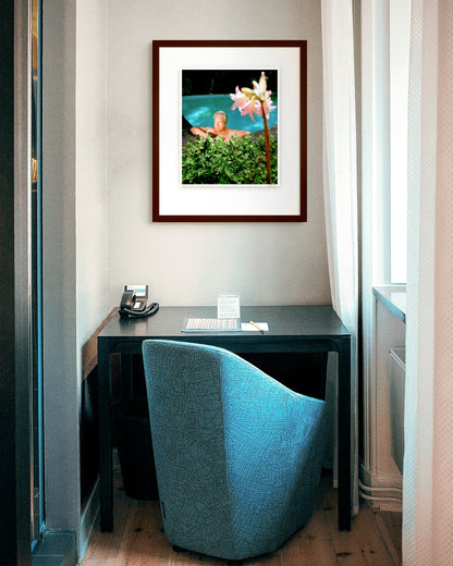 Framed photographic portrait of Don Dunstan by Robin Sellick, part of the Medium Edition series – Dunstan reclining by a pool surrounded by greenery, captured in vivid colour and natural light.