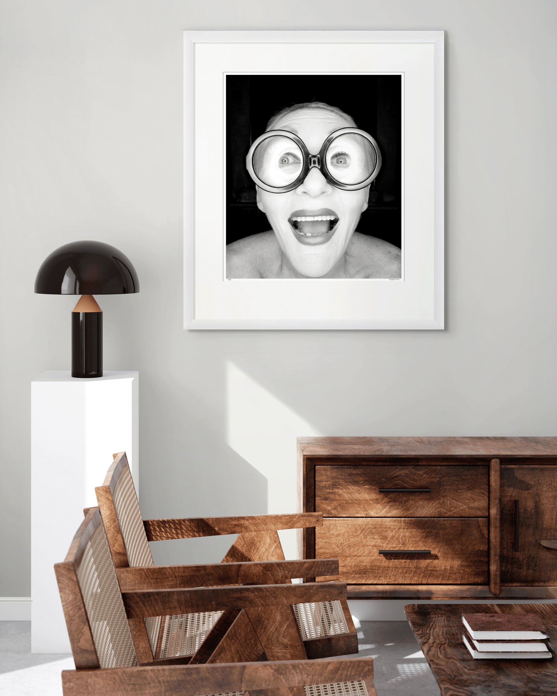 Collector Edition framed black and white photographic portrait of Jeannie Little by Robin Sellick, displayed in a stylish living room with timber furniture and warm natural light.