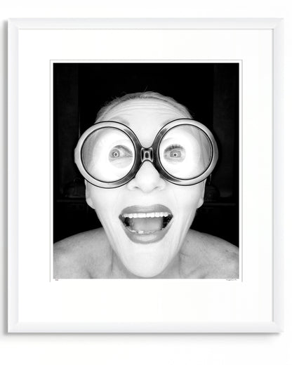 Framed black and white photographic portrait of Jeannie Little by Robin Sellick, part of the Collector Edition series – a bold, joyful image presented in a white frame with wide mat.