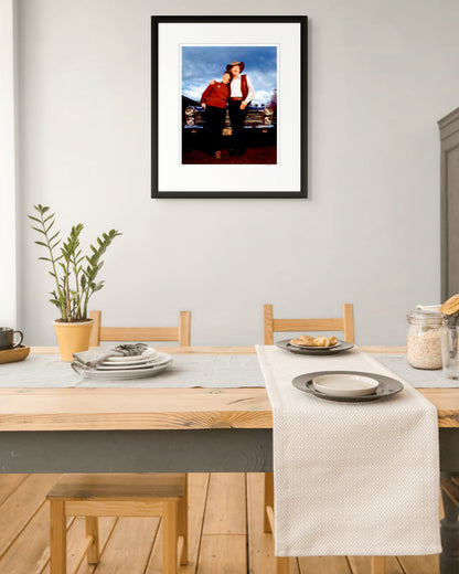 Limited edition framed print of Slim Dusty and Joy McKean by Robin Sellick, hanging above a timber dining table in a soft, natural light setting – evoking warmth, nostalgia and domestic simplicity.