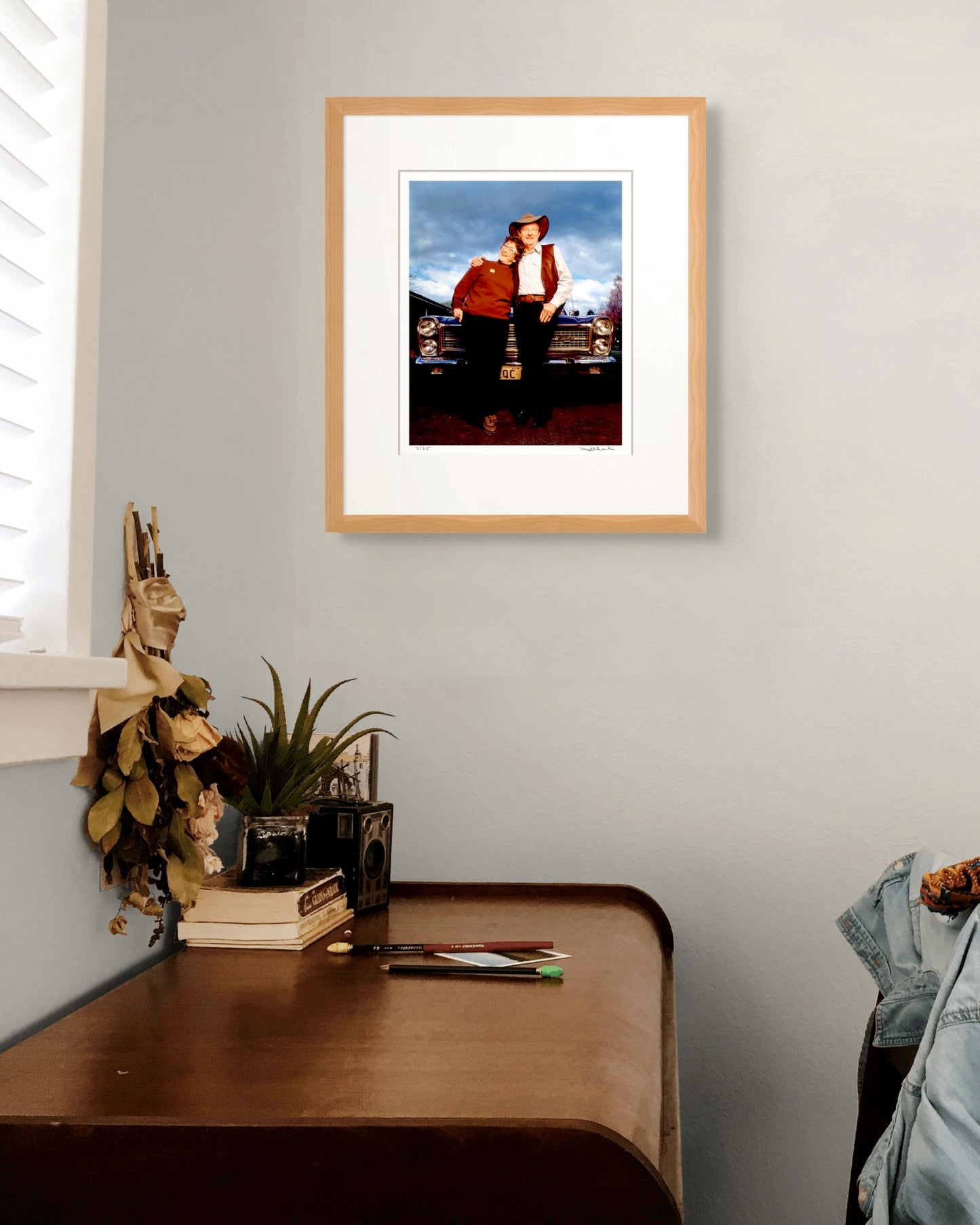 Framed Slim Dusty & Joy McKean portrait above a vintage desk with camera and books – timeless Australian study and collector setting.